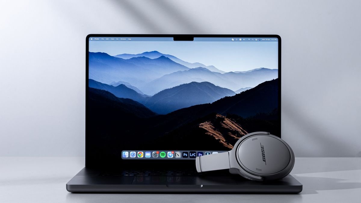 Laptop en koptelefoon op een bureau