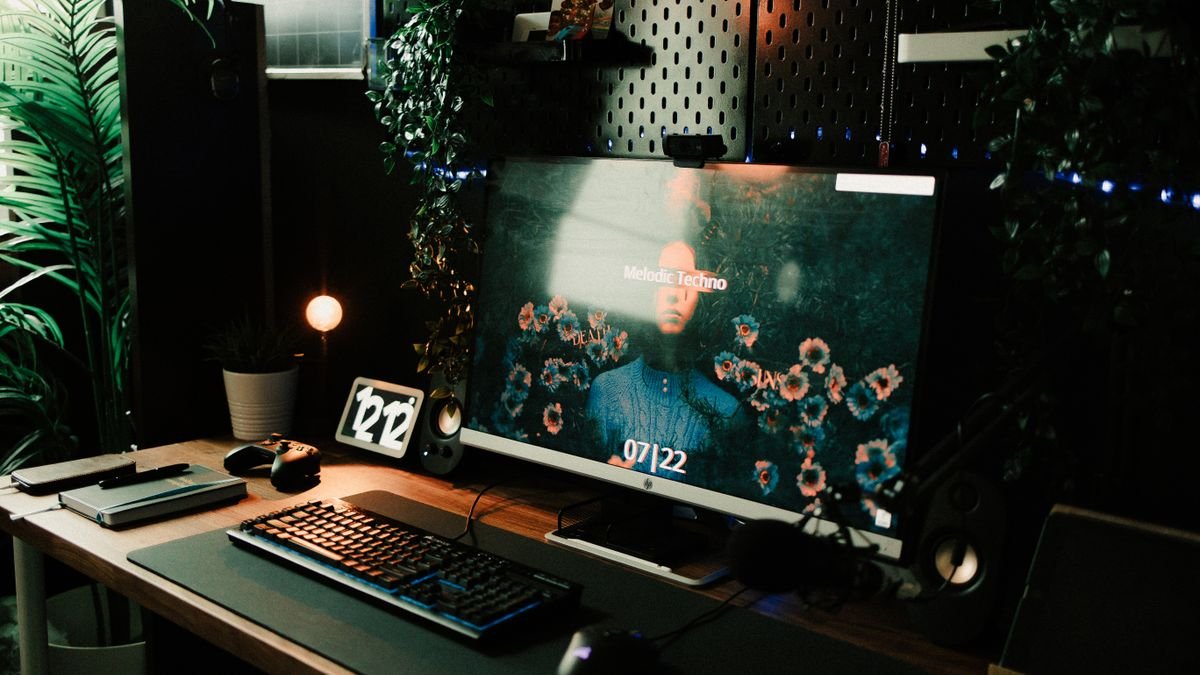 Bureau met scherm, toetsenbord en accessoires in avondlicht