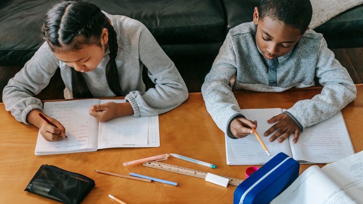 Geconcentreerde kinderen maken huiswerk aan tafel