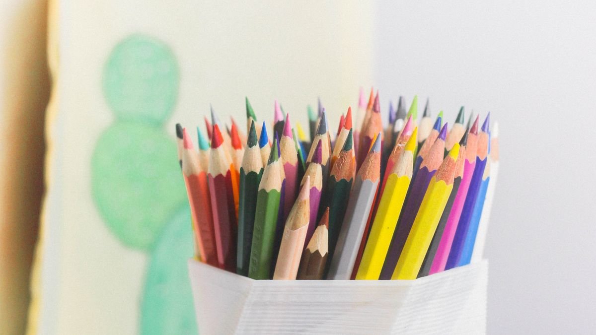 Kleurpotloden in witte houder op klein bureau