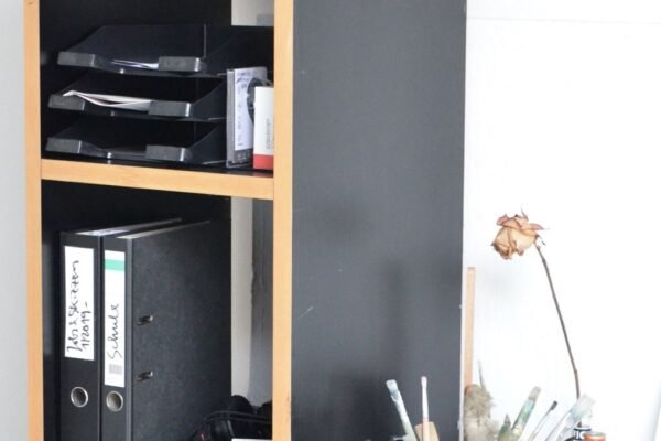 Mappen en dozen op planken naast een bureau