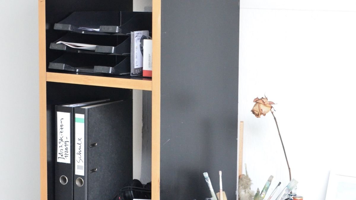 Mappen en dozen op planken naast een bureau