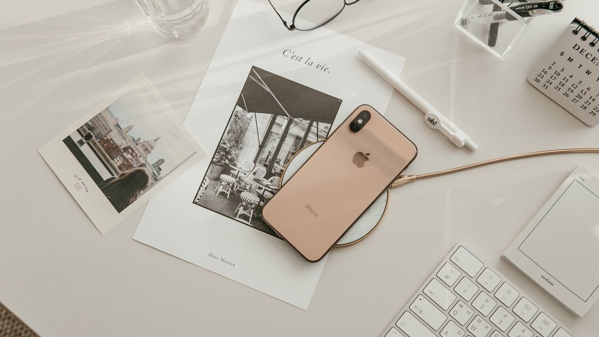 Werkplek met smartphone, toetsenbord en schrijfgerei