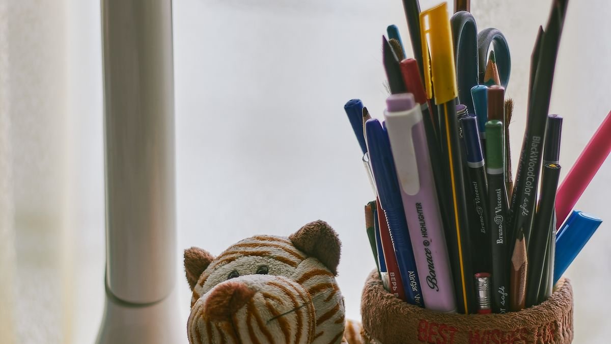 Kinderbureau met kleurrijke schrijfwaren en knuffel