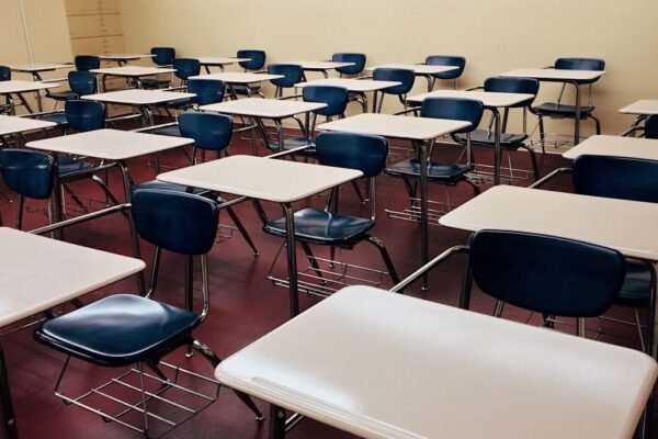 Leeg klaslokaal met rijen schoolbanken