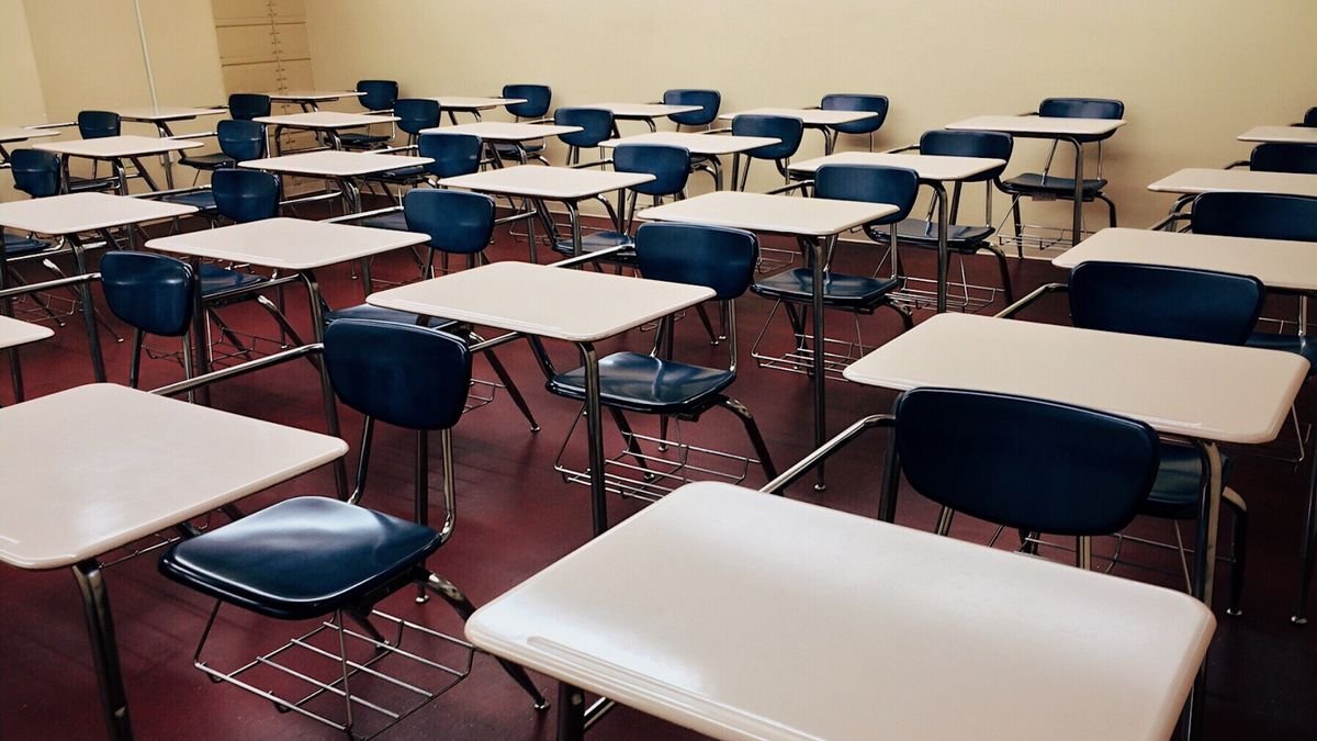 Leeg klaslokaal met rijen schoolbanken