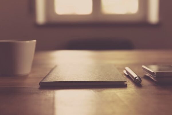 Kop koffie naast smartphone en notitieboek op bureau