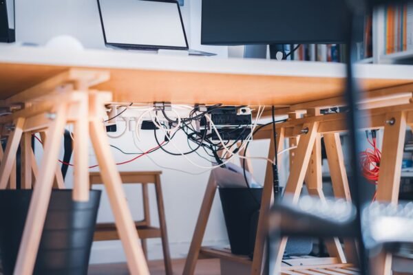Werkplek met zichtbare kabels onder het bureau