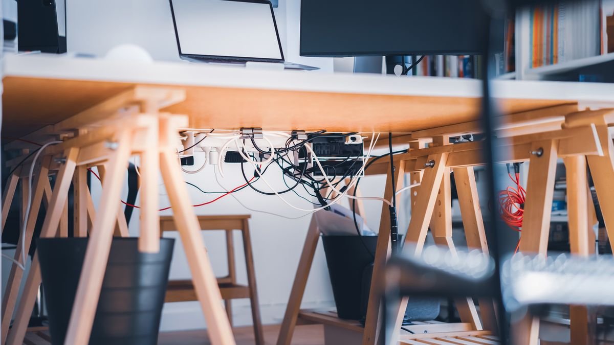 Werkplek met zichtbare kabels onder het bureau
