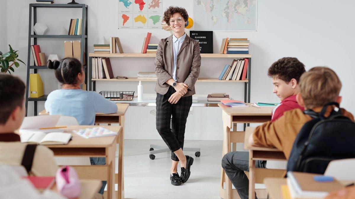 Leerkracht in een klaslokaal met leerlingen en boekenrekken