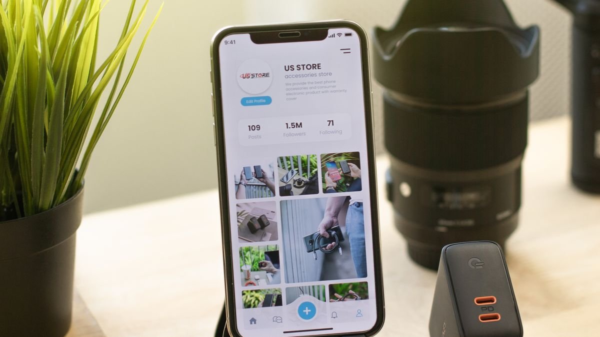 Moderne smartphone op houder naast gadgets op bureau