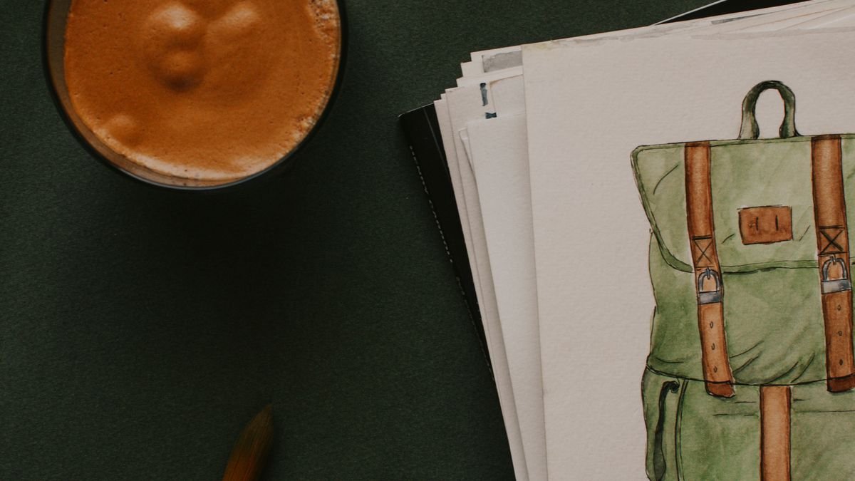 Papier met tekening naast kleurpotloden en penselen