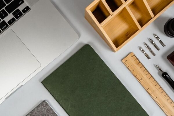Compacte werkplek met laptop, notitieboek en pennen