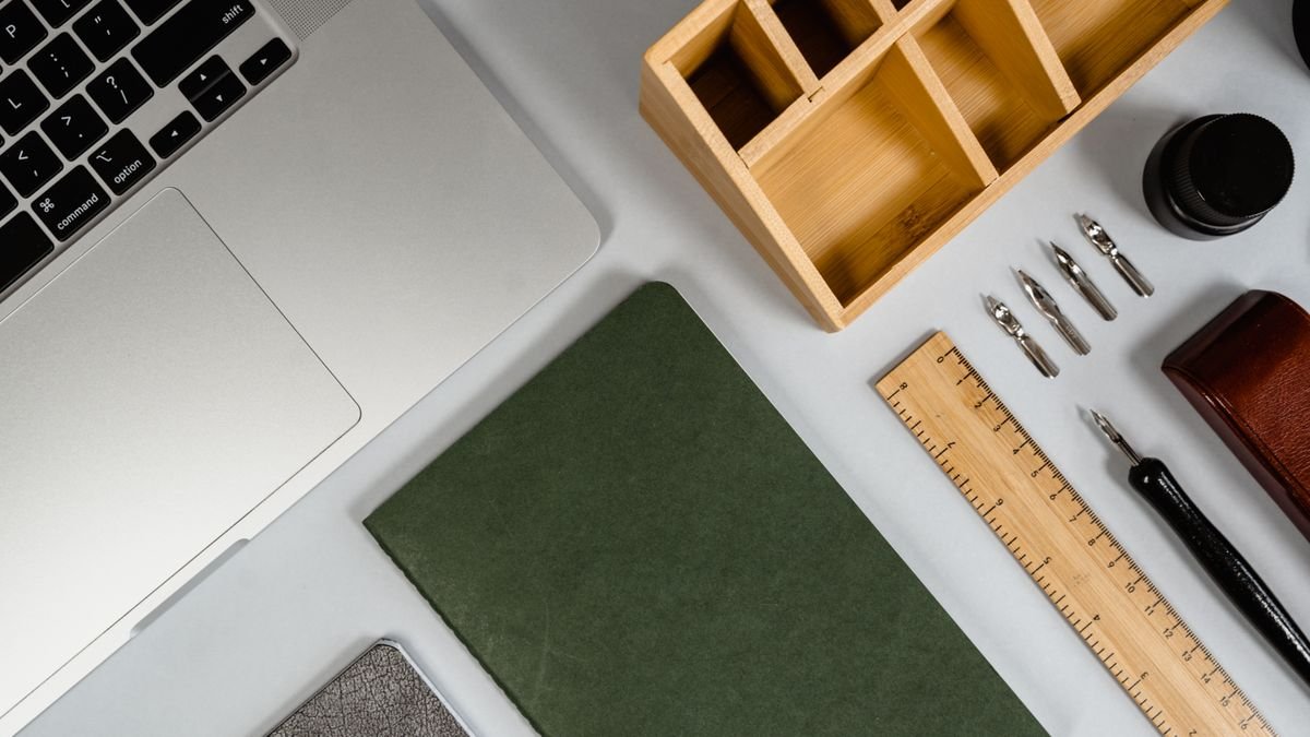Compacte werkplek met laptop, notitieboek en pennen