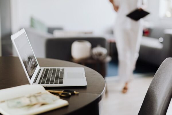 Laptop en notitieboek op een ronde tafel in een lichte kamer