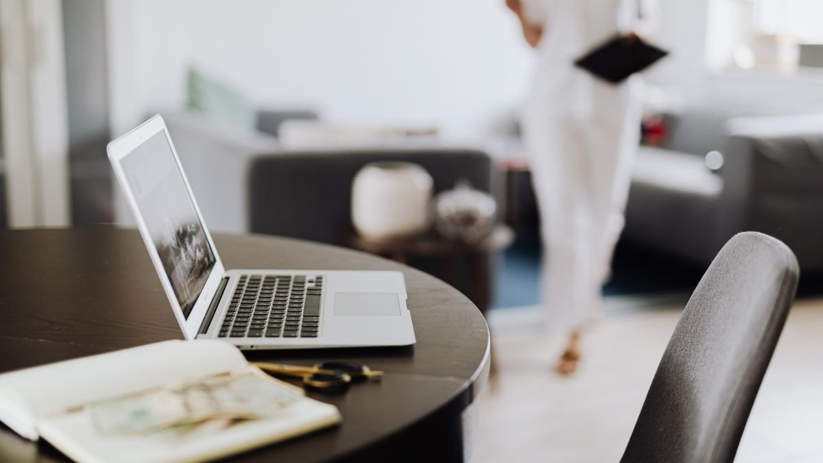 Laptop en notitieboek op een ronde tafel in een lichte kamer
